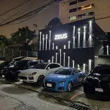 Zeus Karaoke Bangkok - Ekkamai exterior with luxury cars parked at night
