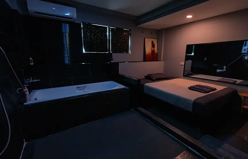 Suite douche chez Heal, douche privée et table de massage dans une salle carrelée de noir
